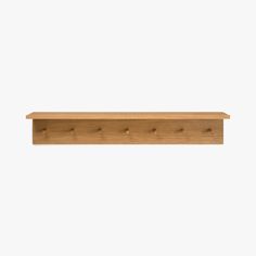 a wooden shelf with three pegs on the top and one in the middle, against a white background