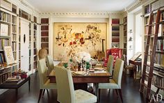 a dining room table surrounded by bookshelves and chairs