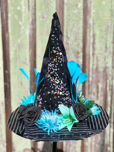 Fancy blue and silver witch hat with striped sparkle fabric, flowers, feathers and rhinestones. Fits up to size 24 inches circumference. Great for Halloween, cosplay, bachelorette parties, weddings, dance recital, dress up and just for fun Whimsical Tall Crown Costume Hat For Party, Whimsical Costume Hat With Tall Crown For Costume Party, Whimsical Tall Crown Costume Hat For Costume Party, Whimsical Costume Hat With Tall Crown For Parties, Whimsical Costume Hats For Carnival Party, Whimsical Costume Hats And Headpieces For Carnival Party, Adjustable Tall Crown Halloween Costume Hat, Adjustable Tall Crown Hats For Halloween, Themed Mini Hats For Party