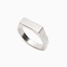 a silver ring with a rectangular design on the top and bottom, set against a white background