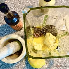 a blender filled with different types of food on top of a counter next to bottles