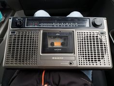 an old radio sitting in the back seat of a car with someone's feet on it