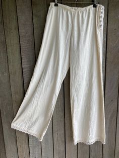 "long loose fit unbleached calico pants loosely elasticised at the waist / hip ( low rise ) with covered button side fastening and with cotton lace edging at the cuff SIZE approx a small - the low waist stretches 29\" to 35\" the hip measures 38\" front rise is 9.5\" back rise is 14\" length down the side seam = 40\" gentle wash" Beige Harem Pants With Pockets For Beach, Beige Harem Pants For Beach With Pockets, Non-stretch Cotton Pants For Vacation, Beige Beach Harem Pants With Pockets, Non-stretch Cotton Beach Pants, Beach Beige Harem Pants With Pockets, Bohemian Straight Leg Non-stretch Bottoms, Beige Cotton Wide Leg Full-length Pants, Bohemian Non-stretch Straight Leg Bottoms