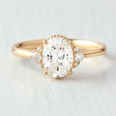 a yellow gold engagement ring with an oval diamond center