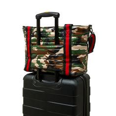 two pieces of luggage are stacked on top of each other, one is black and the other is camouflage