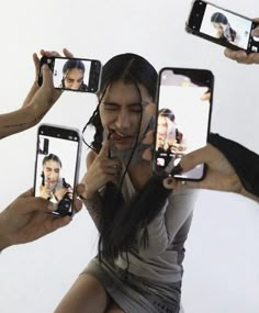 a group of people holding up their cell phones to take pictures with the same person