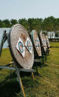 a row of wooden barrels sitting on top of a grass covered field