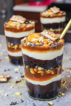 three desserts with chocolate, nuts and caramel in them sitting on a table