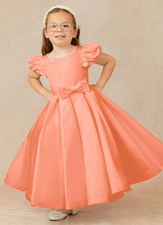 Have your flower girl dressed to impress your friends and family while she wears our matte satin little ballgown, Jewel. Her neckline is jeweled with hand sewn beading, puff sleeves, and a beautiful bow belt that sits atop a full box-pleat tea length skirt. We have matching pearls at the sleeves and a removable back bow. Satin Princess Dress With Fitted Bodice, Satin Princess Dress With Fitted Bodice For Pageant, Elegant Short Sleeve Pageant Gown, Princess Style Satin First Communion Dress, Elegant Wedding Princess Dress, Satin Princess Dress For Dress-up, Elegant Solid Color Princess Dress For Dress-up, Princess Satin Bridesmaid Dress, Satin Princess Bridesmaid Dress