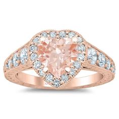 a pink heart shaped diamond ring with white diamonds on the sides and an accent band