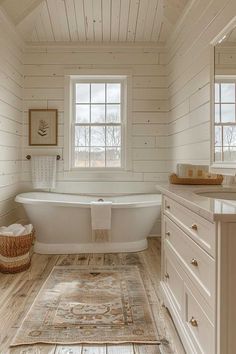 a bathroom with white walls and wood flooring, an antique rug on the floor