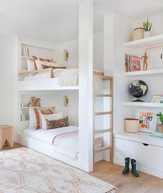 a white bedroom with bunk beds and bookshelves