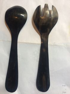 two forks and spoons sitting on top of a white table next to each other