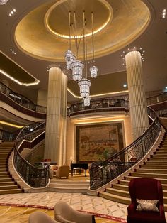 an elegant lobby with chandeliers and marble steps leading up to the second floor