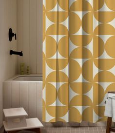 a bathroom with a yellow shower curtain next to a white bath tub and wooden stools