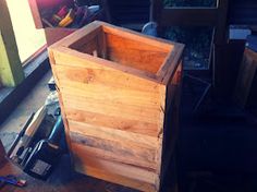 a large wooden box sitting on top of a floor next to a pile of tools