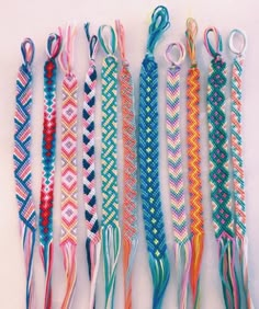 several different colored braided bracelets on a white surface