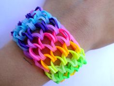 there is a bracelet made out of different colored rubber bands on someone's arm