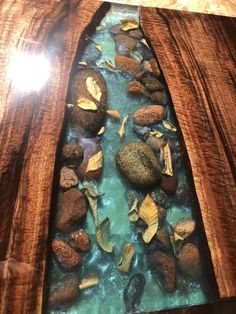 a wooden table with rocks and water in it