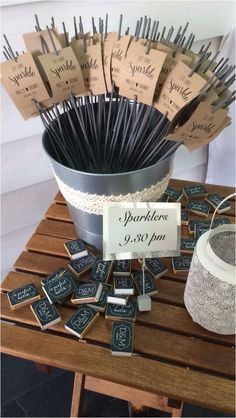 a bucket full of matches sitting on top of a wooden table next to a sign