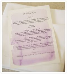 the wedding program is on top of some napkins with watercolor paper around it