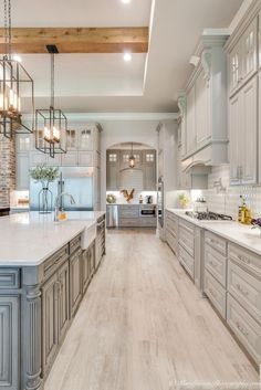 a large kitchen with wooden floors and gray cabinets