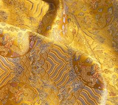 a yellow and blue fabric with an intricate design on the top, in very close up