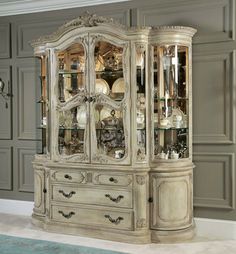 an antique china cabinet with glass doors and drawers in the middle of a living room