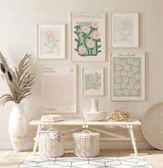 a white table topped with vases filled with flowers next to pictures on the wall