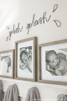 three framed photos hang on the wall above a towel rack with two baby's names