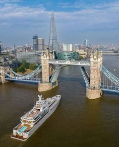 an aerial view of the london bridge and river thames, with a boat in the foreground