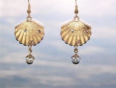 These are handcrafted gold color shell dangle pierced earrings made from novelty charms.  Each earring hangs about 1-3/4" long,  The gold color is not as dark as it comes through the pictures and they have sparkle gems that don't show well in the pictures.  The wire used is a gold color.   At this time I have to ship ONLY to U.S. addresses. Gold Shell-shaped Brass Earrings, Gold Brass Shell-shaped Earrings, Gold Brass Shell Earrings, Gold Shell-shaped Metal Earrings, Adjustable Gold Earrings With Dangling Charms, Gold Earrings With Dangling Charms, Gold Shell-shaped Earrings With Ear Wire, The Wire, Pierced Earrings