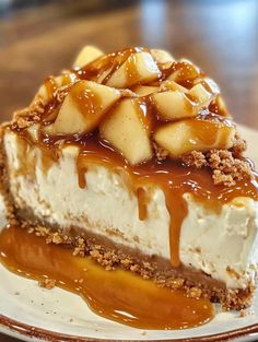 a piece of cheesecake with caramel sauce and apples on top sits on a plate