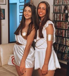 two beautiful young women standing next to each other in front of a book shelf filled with books