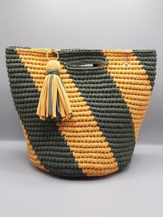 a green and yellow basket with a tassel