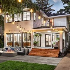 an image of a house with lights on the front porch and patio area in the evening