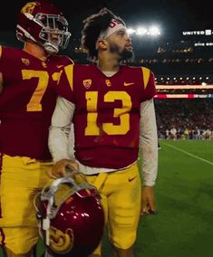 two football players standing next to each other on a field