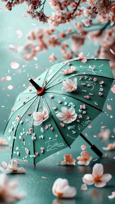 an umbrella with pink flowers on it and water droplets falling from the sky behind it