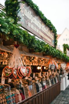 christmas wreaths hanging from the side of a building in front of a market stall