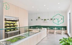 the inside of a restaurant with many food items on display in glass cases and hanging plants