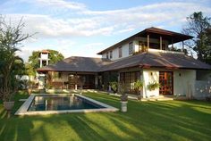 a house with a pool in the front yard and grass on the lawn below it