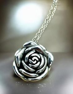 Elevate your jewelry collection with our exquisite Rose Flower Pendant Necklace, masterfully crafted from premium 925 Sterling Silver. This hollow-formed pendant showcases an intricate rose design, offering an elegant and timeless aesthetic. The pendant dimensions are a tasteful 1 inch by 1 inch, perfect for making a subtle yet impactful statement. For a harmonious look, you have the option to pair the pendant with a matching 18-inch cable link necklace, also fashioned from high-quality 925 Ster Rose Sterling Silver Necklace For Anniversary, Rose-colored Sterling Silver Necklace For Anniversary, Silver Rose Design Necklace For Anniversary, Elegant Silver Necklace With Rose Design, Silver Necklace With Rose Design, Elegant Rose Sterling Silver Necklace, Silver Rose Design Jewelry For Formal Occasions, Silver Rose Detail Sterling Silver Jewelry, Rose Sterling Silver Jewelry For Mother's Day