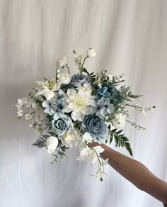 a bouquet of flowers is being held by a person's hand on a white background