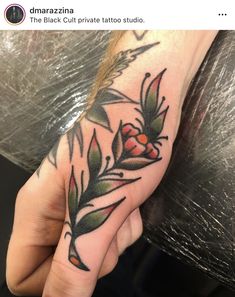 a person's hand with a flower tattoo on it