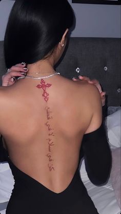 the back of a woman's body with writing on her left shoulder and chest