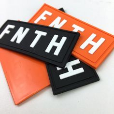 three orange and black magnets with the word finish on them, sitting next to each other