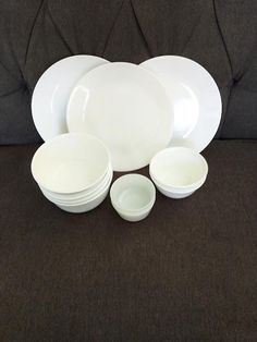 a set of white dishes sitting on top of a couch