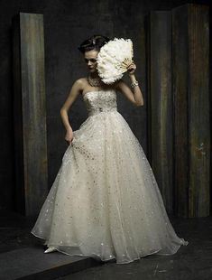 a woman in a white dress holding a large flower