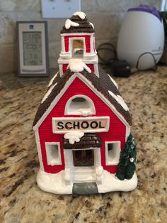 a small red and white school building on a counter