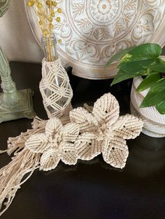 two crocheted flowers are sitting on a table